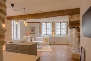 a living room with a white couch and windows at Le Clos du XVIe - Exceptional accommodation in Orléans
