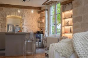 a kitchen with a counter and a bar with chairs at Le Clos du XVIe - Exceptional accommodation in Orléans