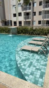 a swimming pool with lounge chairs and a building at Ap Mirante Fortaleza 5min da Praia com Piscina e Rooftop para 6 pessoas in Fortaleza