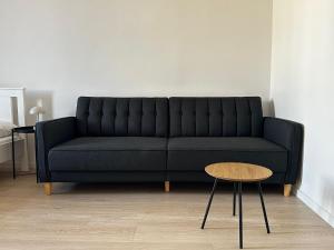 a black couch in a living room with a table at Casa Ventuno in Civitavecchia