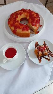 a table with two plates of food and a cup of coffee at Hotel Cadore in Bauru