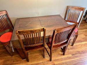 a wooden table with two chairs and a wooden table with a wooden table at Unique main square apartment - AC - Balcony - Coffee Machine - Washer - Kitchen- Parking available Free public or Paid Private for 20 euro per stay Please read our emails in Poprad