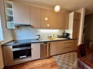 a kitchen with stainless steel appliances and wooden floors at Unique main square apartment - AC - Balcony - Coffee Machine - Washer - Kitchen- Parking available Free public or Paid Private for 20 euro per stay Please read our emails in Poprad