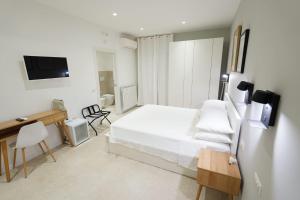 a bedroom with a bed and a desk and a television at ResidenzaMarèa in Scalea