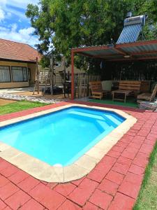 a swimming pool in a yard with a patio at The Converted Space in Welkom