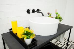a bathroom with a sink and flowers on a table at GET a Cactus and Books studio in Porto
