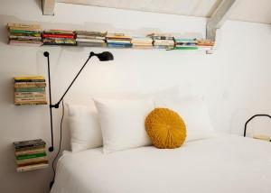 a bedroom with a bed with a lamp and books at GET a Cactus and Books studio in Porto