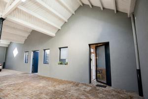 an empty room with white walls and ceilings with windows at GET a Cactus and Books studio in Porto