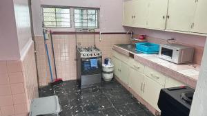 a dirty kitchen with a stove and a microwave at Peace N' Green - APARTMENTS - Doleguita in David