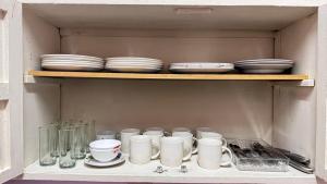 a cabinet filled with plates and cups and bowls at Peace N' Green - APARTMENTS - Doleguita in David