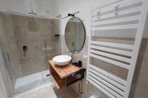 a bathroom with a sink and a shower with a mirror at ResidenzaMarèa in Scalea