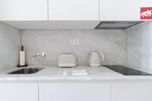 a kitchen counter with a sink and a mixer at Get a Golden and Flower Flat in Porto