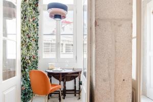 a dining room with a table and chairs and a window at Get a Golden and Flower Flat in Porto