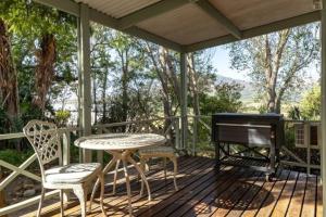 a patio with a table and a piano on a deck at Five Mountains Guest Farm & Spa in Wellington