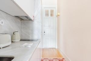 a room with a white door and a sink at Get a Golden and Flower Flat in Porto