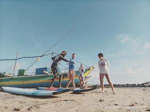 a group of people standing on surfboards on the beach at Villa Nature Glee in Dodanduwa