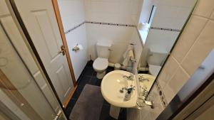 a small bathroom with a sink and a toilet at Beachfront Apartments in Sligo