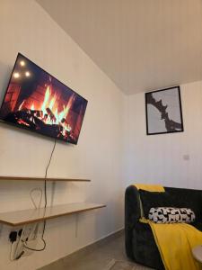 a living room with a fireplace and a tv on the wall at Misty Cabins in Ruringʼu +3 photos