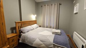 a small bedroom with a bed and a shower at Beachfront Apartments in Sligo