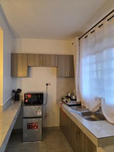 a small kitchen with a sink and a microwave at Misty Cabins in Ruringʼu