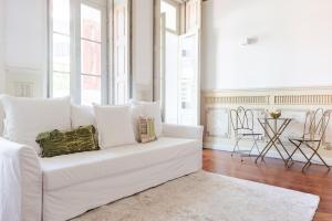 a white couch in a living room with windows at Get a Unique and Luxury Flat in Porto +17 photos