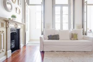a white couch in a living room with a fireplace at Get a Unique and Luxury Flat in Porto