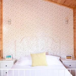 a bedroom with a white bed and a wall at Lawrencetown Lodge - The Maple Studio in Three Fathom Harbour