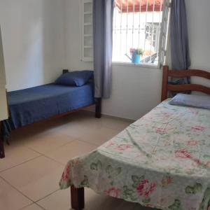 a bedroom with a bed and a window with a table at Casa Bela in Itamaracá