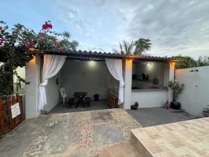 a house with a patio with a table and flowers at Pousada Buganvília in Tianguá