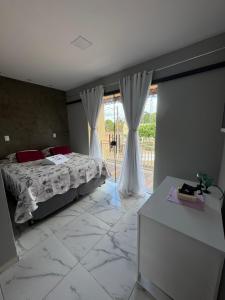 a bedroom with a bed and a large window at Pousada Buganvília in Tianguá +23 photos