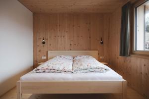 a bed in a room with a wooden wall at Ferienwohnung Flatz in Egg