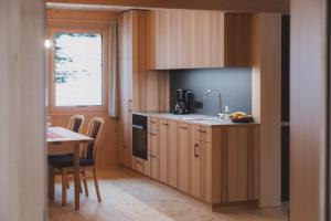 a kitchen with wooden cabinets and a table and a window at Ferienwohnung Flatz in Egg +16 photos