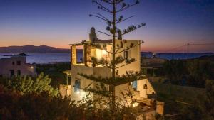 a white house with a tree in front of it at Matina's Family in Mikri Vigla