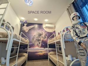 a room with two bunk beds and an astronaut mural at Fontana Oasis Apartment in Castelnuovo del Garda