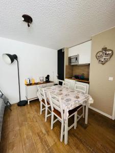 a dining room with a table and chairs and a kitchen at LE FONTAGNEL N°310 in Molines-en-Queyras