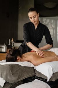 a woman getting a back massage from a massage therapist at Chalet Mirabell in Avelengo