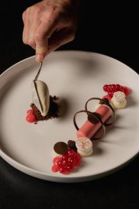 a person eating a dessert with a fork on a plate at Chalet Mirabell in Avelengo