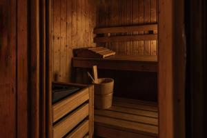 a wooden sauna with a bench and a bucket at Hotel Valentino in Acqui Terme
