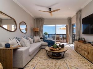 a living room with a couch and a tv at Waves & Whales in Brenton-on-Sea