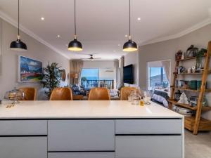 a kitchen and living room with a view of the ocean at Waves & Whales in Brenton-on-Sea