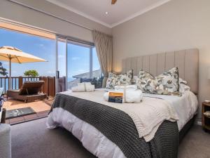 a bedroom with a bed with a view of the ocean at Waves & Whales in Brenton-on-Sea +39 photos