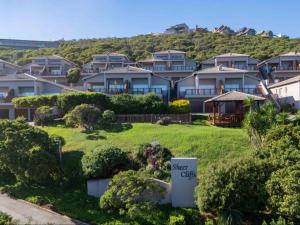 a row of houses on a hill with a sign for a star club at Waves & Whales in Brenton-on-Sea