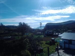 a view of a town with mountains in the background at Ambewela Pattipola snowflak rest in Nuwara Eliya