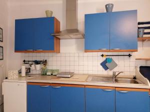 a kitchen with blue cabinets and a sink at la scogliera in Vernazza +33 photos