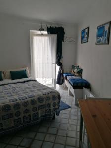 a bedroom with a bed and a desk and a window at la scogliera in Vernazza