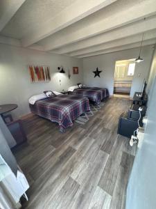a bedroom with two beds and a table and chairs at Tecumseh Inn & Suites in Tecumseh