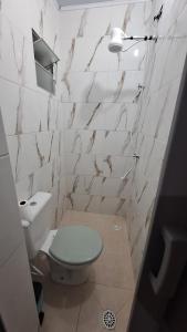 a white bathroom with a toilet and a sink at Casa kitnet in São Caetano do Sul