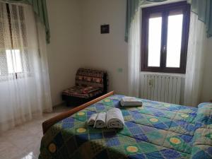 a bedroom with a bed with towels and a chair at La Vecchia Fontana in Penne