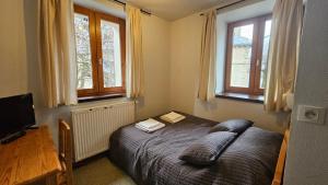 a bedroom with a bed with two books on it at Auberge La Cure in Oz