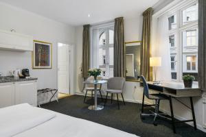 ein Zimmer mit Bett, Schreibtisch und Küche in der Unterkunft Hotel Tiffany in Kopenhagen